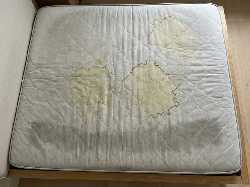 Colchão branco com manchas amareladas